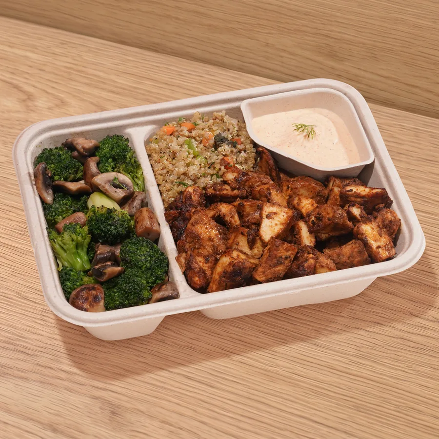 A FOJO tray of cajun chicken with quinoa, broccoli and mushroom sauté and sriracha yogurt