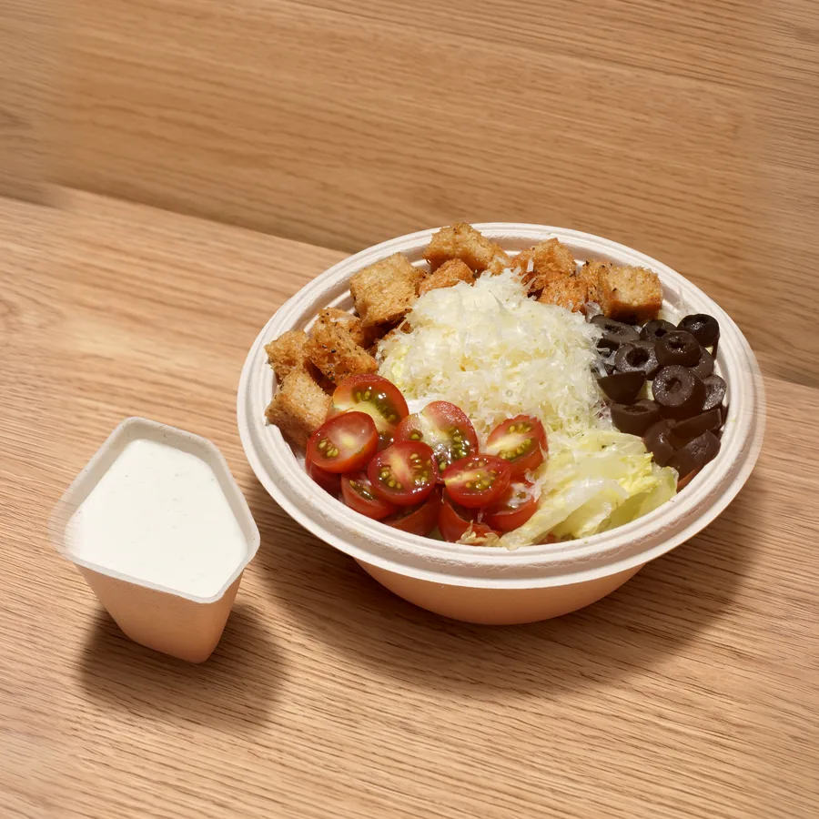 A FOJO Caesar salad with croutons, cherry tomatoes and olives, dressing on the side