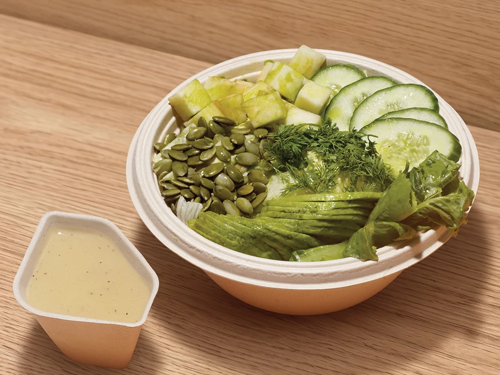 A FOJO salad bowl with greens, cucumber and pumpkin seeds